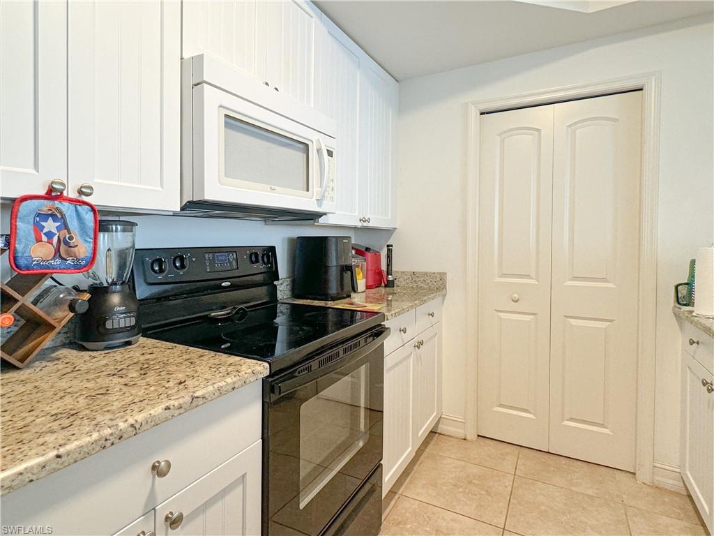 1100 Pine Ridge Road, Unit 201B Naples, FL 34108 - Photo 7 of 18 a kitchen with stainless steel appliances granite countertop a stove and a microwave