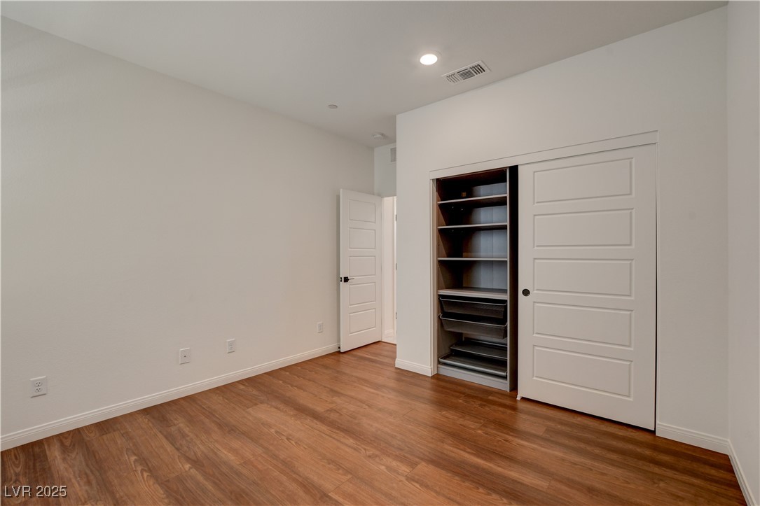 5406 Zacatin Court Las Vegas, NV 89166 - Photo 7 of 23 Unfurnished bedroom featuring baseboards, wood fin
