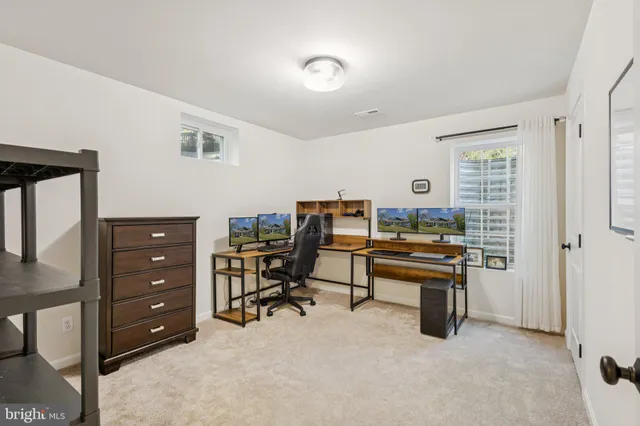 a view of a workspace with furniture and a window
