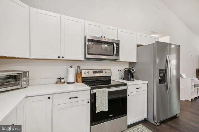 a kitchen with refrigerator a microwave and cabinets
