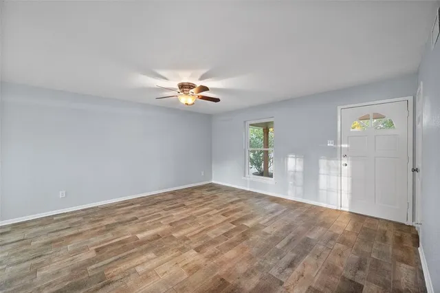 a view of an empty room with a chandelier fan