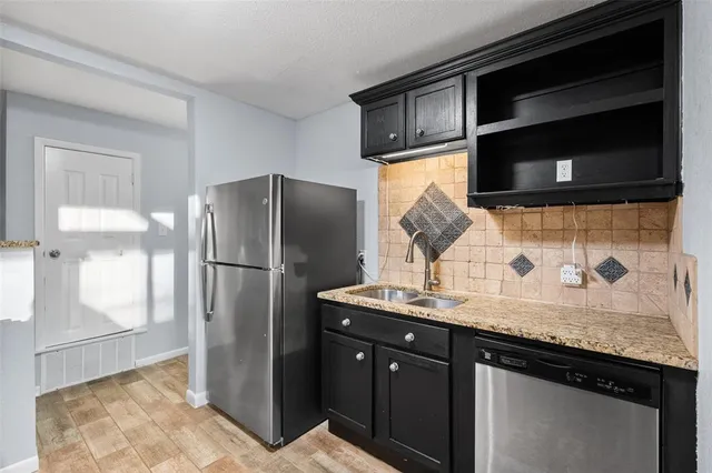 a kitchen with stainless steel appliances granite countertop a refrigerator and a sink