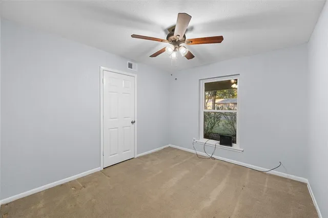 a view of a livingroom with a ceiling fan and window