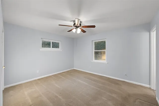 a view of a room with a ceiling fan and a window