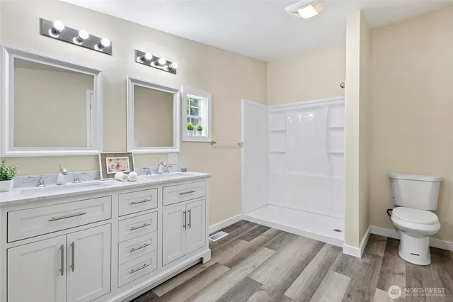 a bathroom with a toilet a sink a mirror and vanity