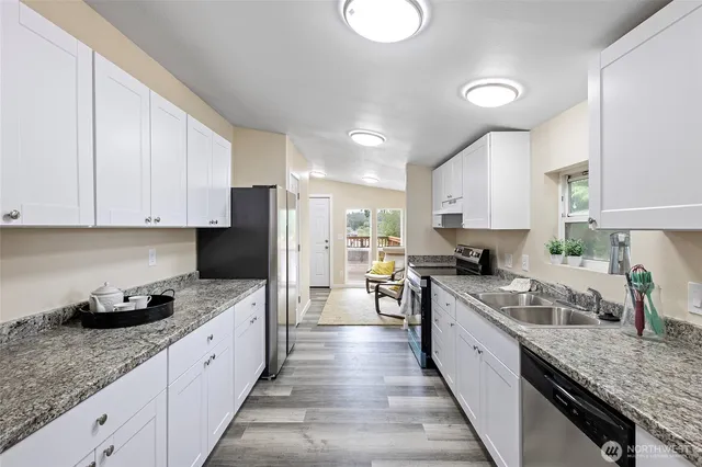 a kitchen with granite countertop sink stainless steel appliances and cabinets