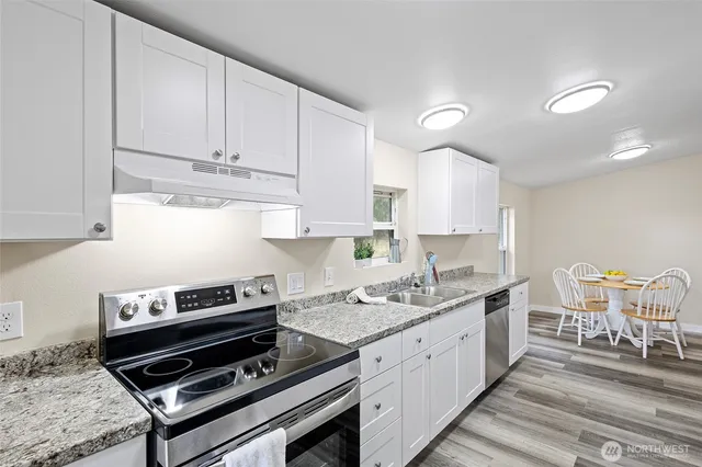 a kitchen with a stove a sink and cabinets