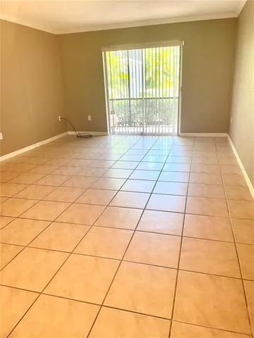 a view of a livingroom with an empty space and a window