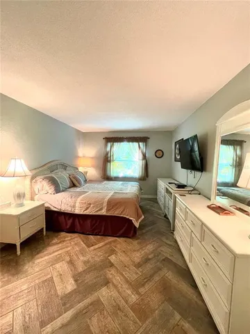 a spacious bedroom with a bed and a flat screen tv