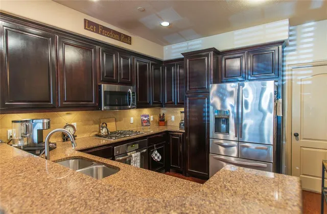 a kitchen with granite countertop a refrigerator and a sink