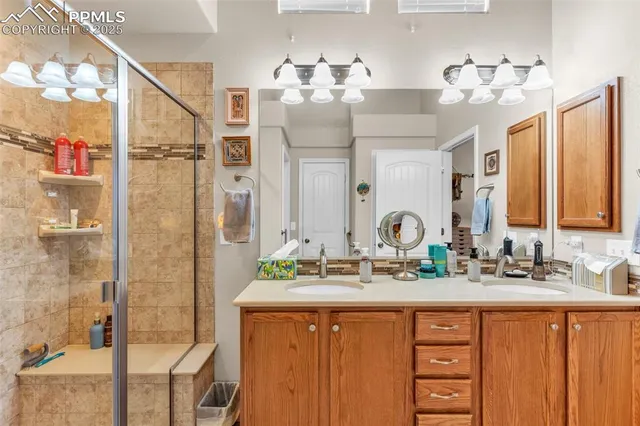a bathroom with a double vanity sink mirror and shower