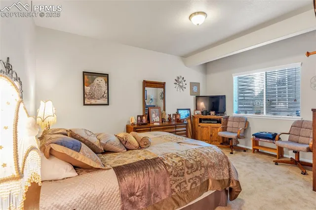 a bedroom with a bed a table and a flat screen tv