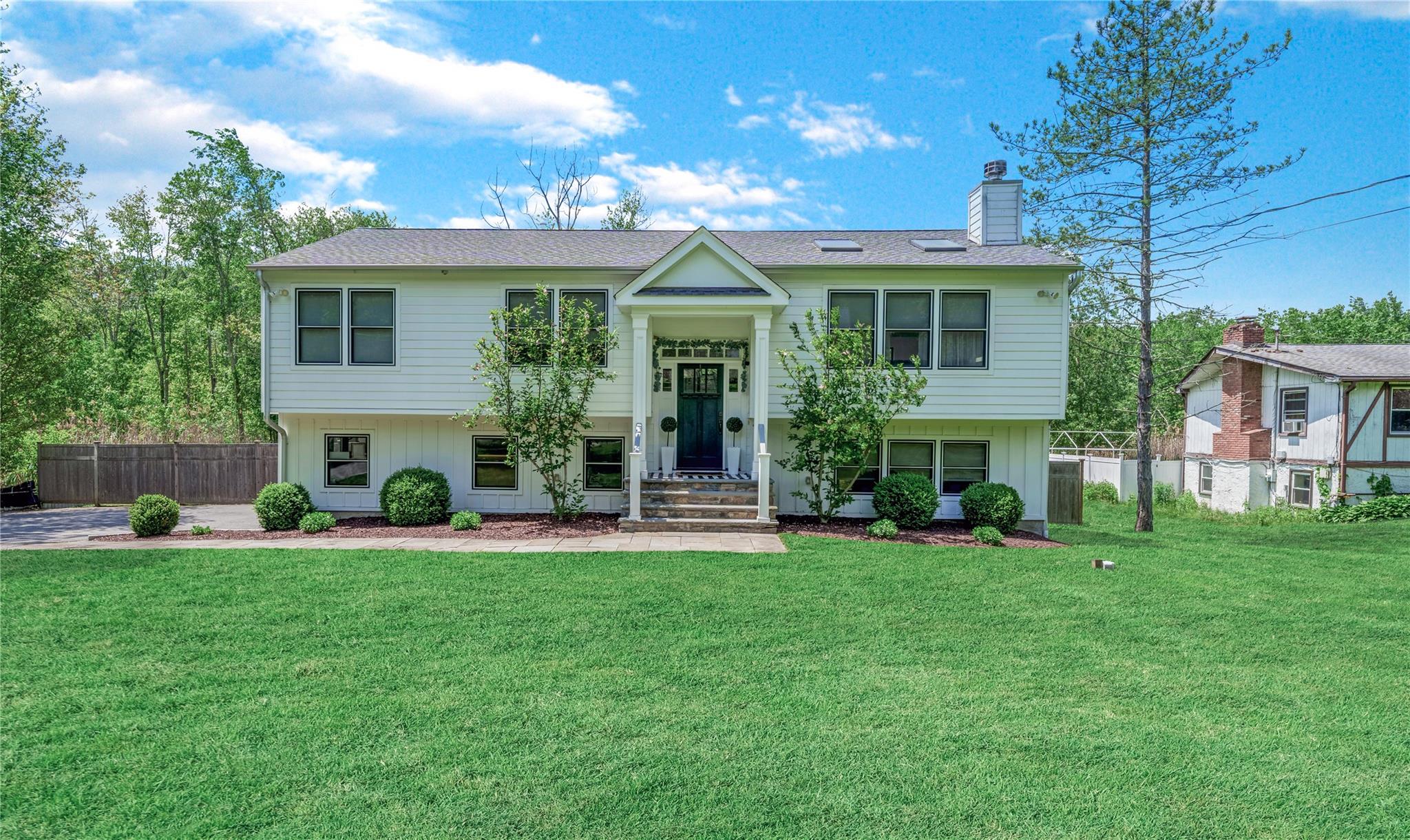 Bi-level home featuring a chimney and a shingled roof