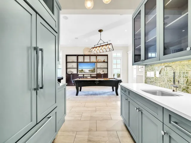 a large kitchen with stainless steel appliances kitchen island granite countertop a large counter top and view of living room