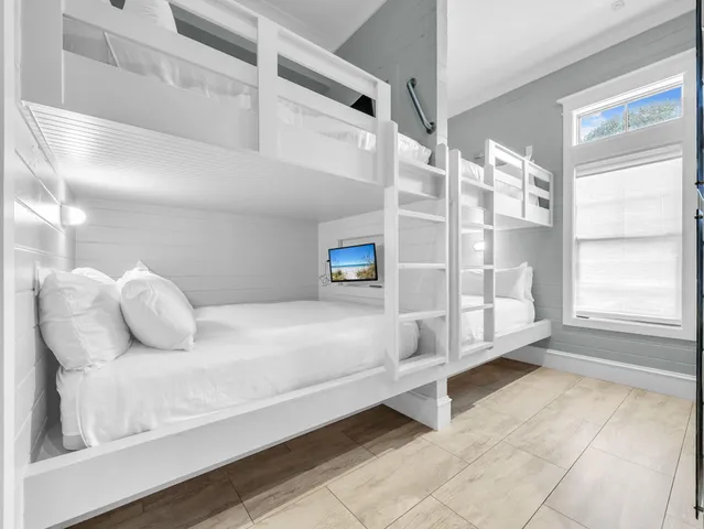 a large kitchen with stainless steel appliances a stove a sink dishwasher and white cabinets with wooden floor