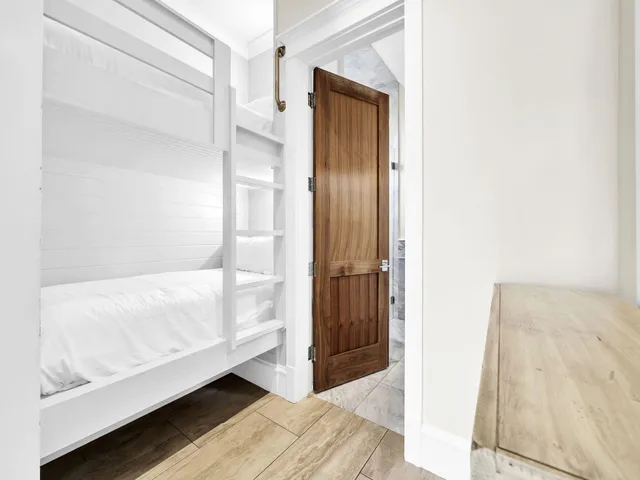 a bedroom with a bed dresser and wooden floor