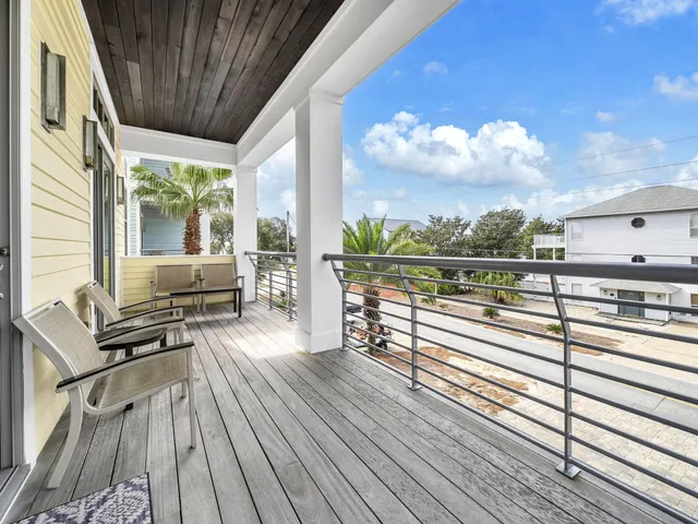 a view of a balcony with chairs and wooden floor