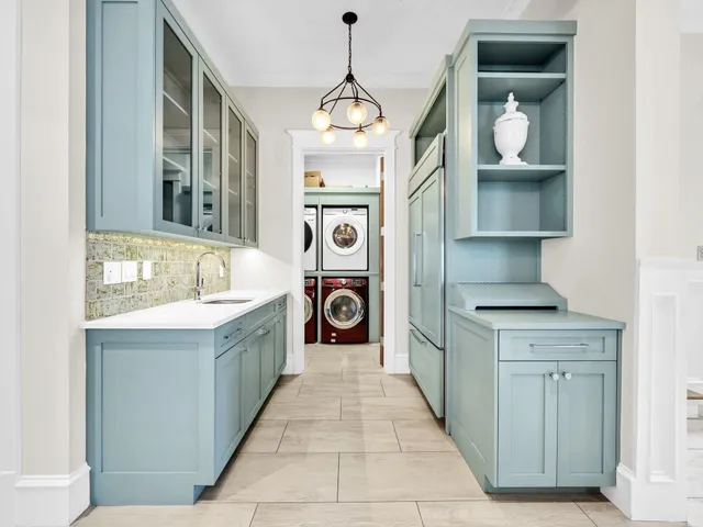 a living room with furniture kitchen view and a window