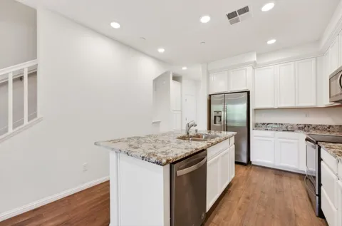 a kitchen with a sink a stove a refrigerator and a refrigerator