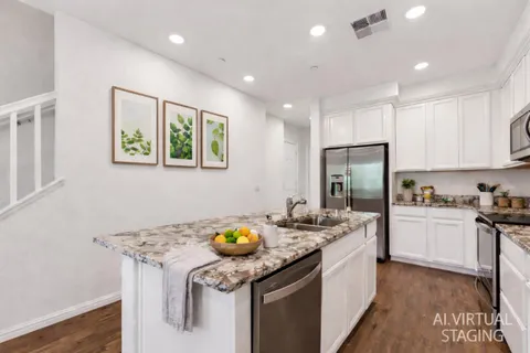 a kitchen with stainless steel appliances granite countertop a sink stove refrigerator and cabinets