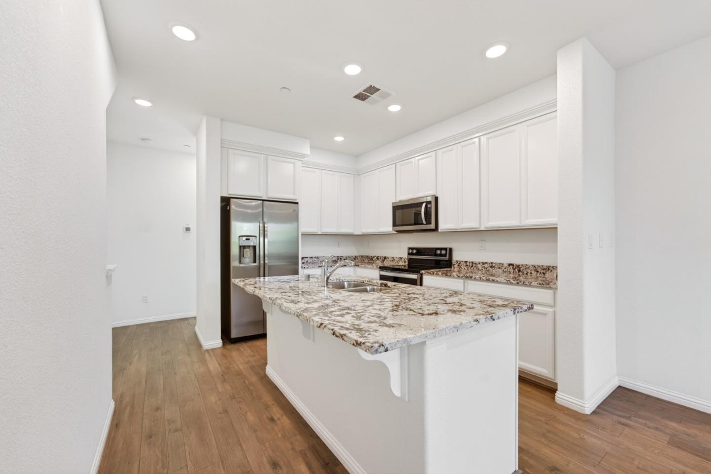 2580 Gimelli Way San Jose, CA 95133 - Photo 19 of 50 a kitchen with stainless steel appliances granite countertop a sink stove refrigerator and cabinets