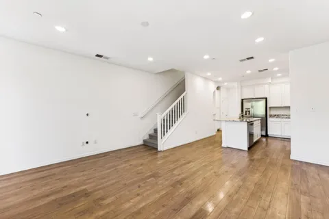 a view of an empty room with wooden floor