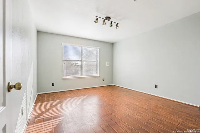 wooden floor in an empty room with a window