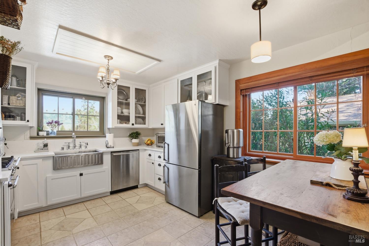 151 High Street Calistoga, CA 94515 - Photo 21 of 52 a kitchen with stainless steel appliances granite countertop a refrigerator a sink dishwasher a stove and a dining table with wooden floor