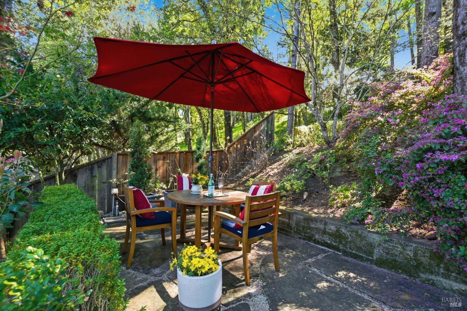 151 High Street Calistoga, CA 94515 - Photo 40 of 52 a patio with tables and chairs under an umbrella