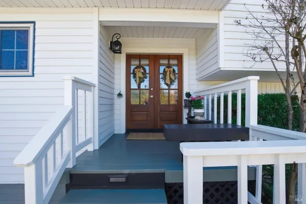 a view of a patio with table and chairs with wooden floor and fence
