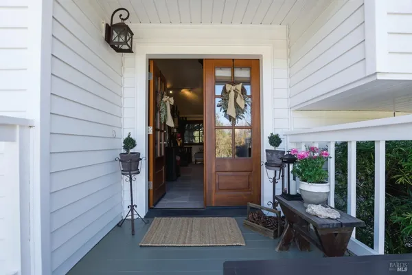 a view of a porch with chairs and potted plants