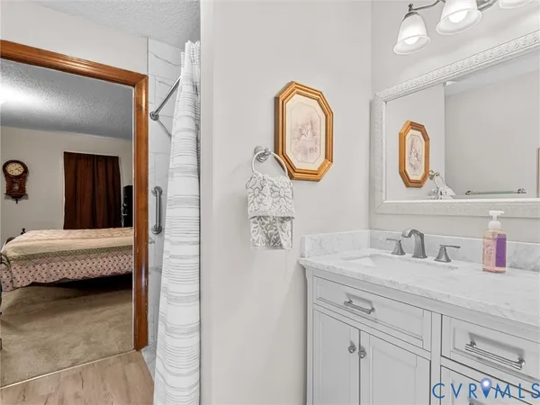a bedroom with a bed a dresser and next to a window