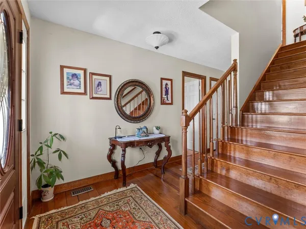 a view of a hallway with wooden floor and a chandelier