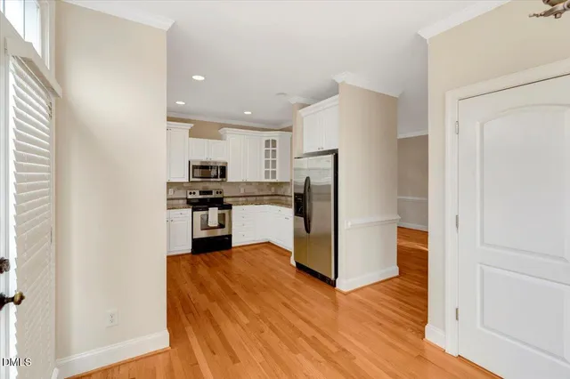 a kitchen with a refrigerator a stove top oven and cabinets