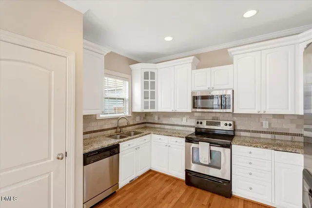 a kitchen with white cabinets and appliances