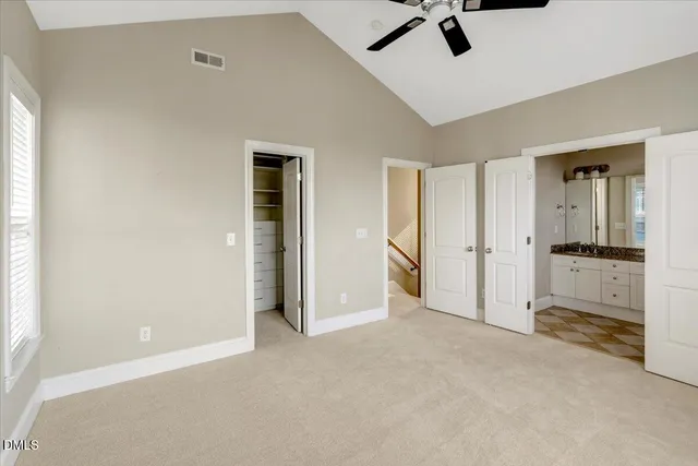 an empty room with closet and a chandelier fan