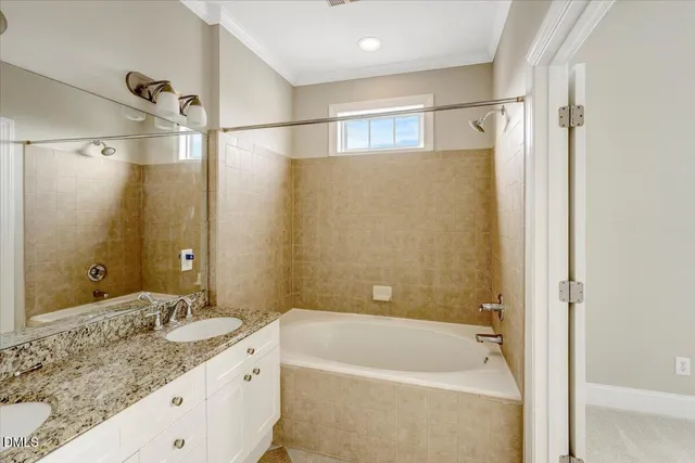 a bathroom with a granite countertop bathtub shower sink vanity and mirror