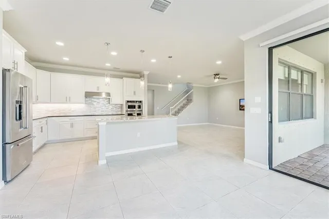 a open kitchen with white cabinets and stainless steel appliances