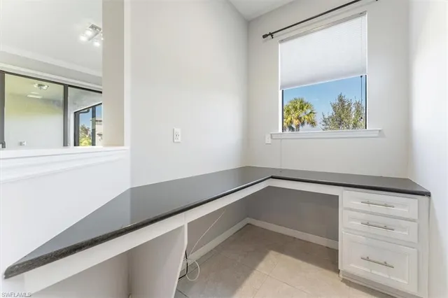 a view of a hallway to a bedroom with wooden floor and cabinet