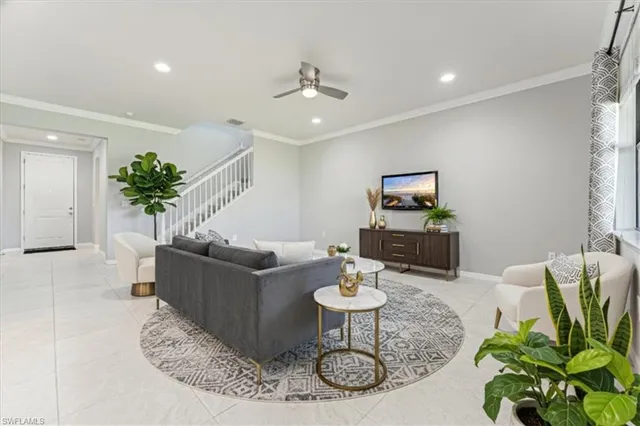 a living room with furniture a potted plant and a chandelier