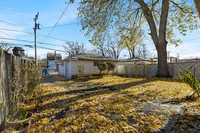 a view of a yard with wooden fence