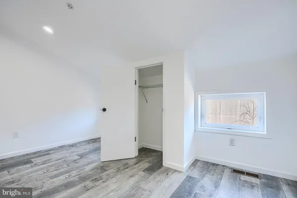 an empty room with wooden floor and window