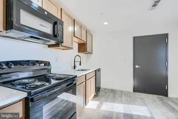 a kitchen with a stove and a wooden floor