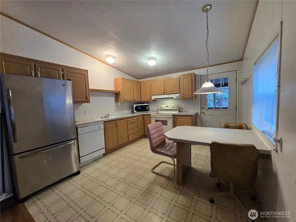 a kitchen with refrigerator cabinets and a table