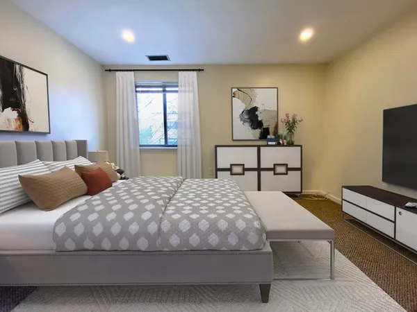 a bedroom with two beds and a flat screen tv