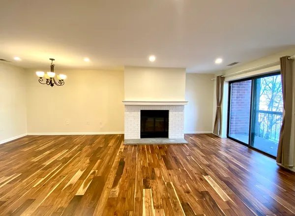 a view of empty room with wooden floor and fireplace