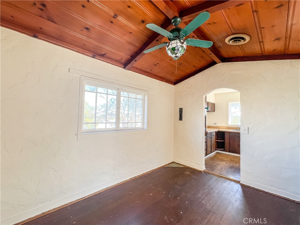 506 Desnok Street Needles, CA 92363 - Photo 21 of 70 an empty room with wooden floor chandelier fan and windows