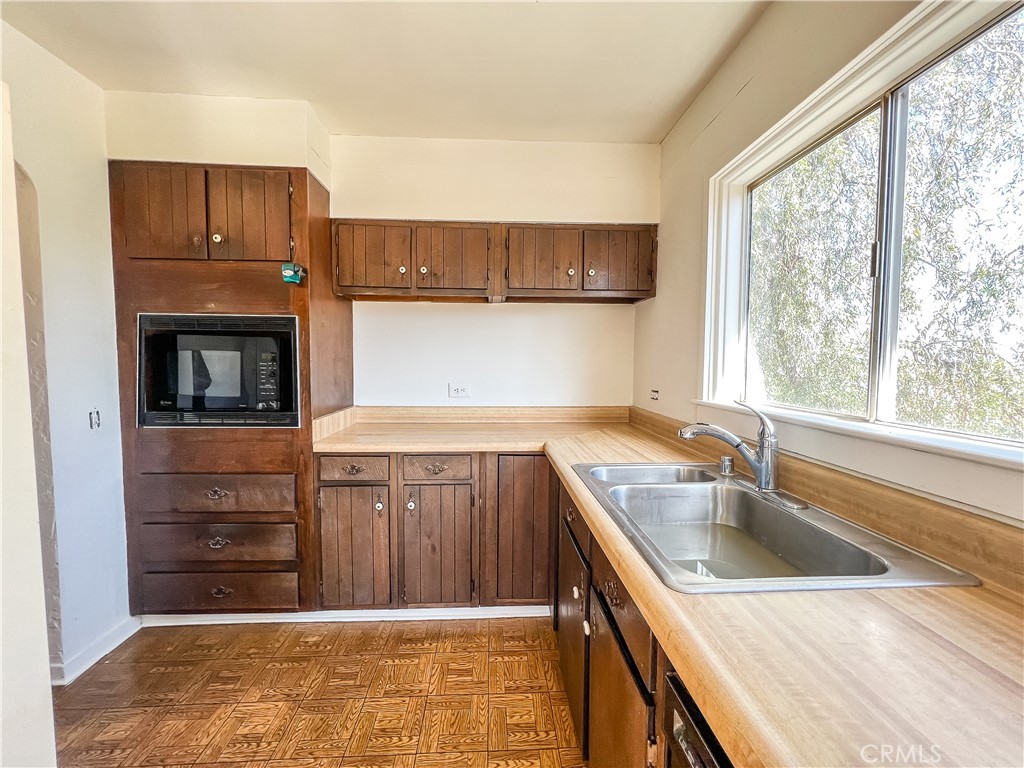 506 Desnok Street Needles, CA 92363 - Photo 33 of 70 a kitchen with a sink cabinets stainless steel appliances and a large window