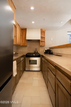 a kitchen with a sink a stove top oven and cabinets