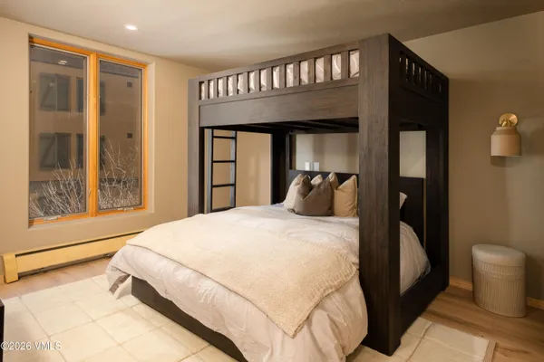 a bedroom with a bed and dresser with mirror